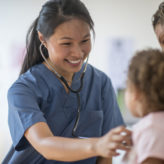 nurse checks on pediatric patient