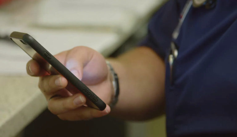 close-up of a phone being used to reduce physician burnout