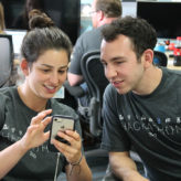 two Mobile Heartbeat employees collaborate with a smartphone