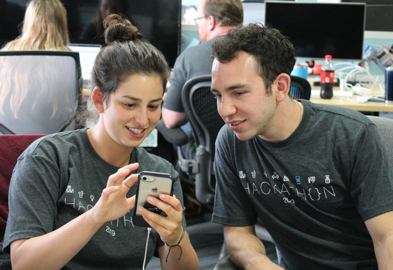 two Mobile Heartbeat employees collaborate with a smartphone