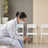 masked doctor sitting in waiting area