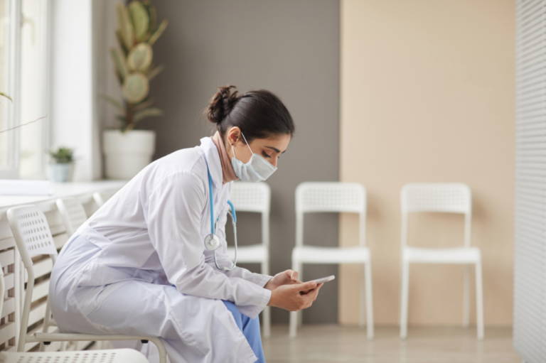 masked doctor sitting in waiting area