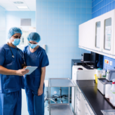 surgeons confer over a tablet